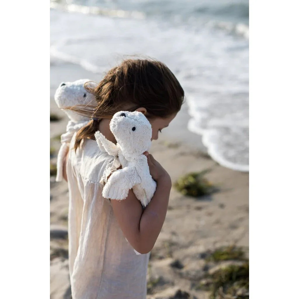 Liten jente med hvit plysdyr på stranden, myke barneklær og babyutstyr for 0-8 år