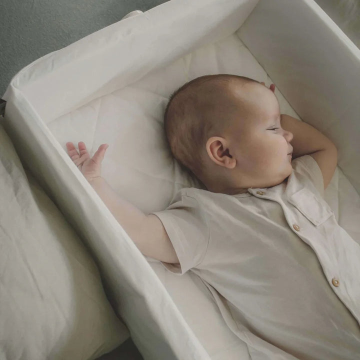 Søvnende baby i hvit seng med myk barneklær og ull, perfekt for 0-8 år