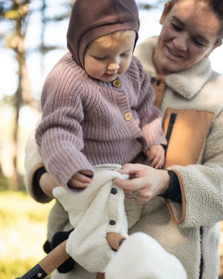 Liten baby i myk ullgenser og hette, holdt av mor i naturen – perfekt barneklær 0-8 år