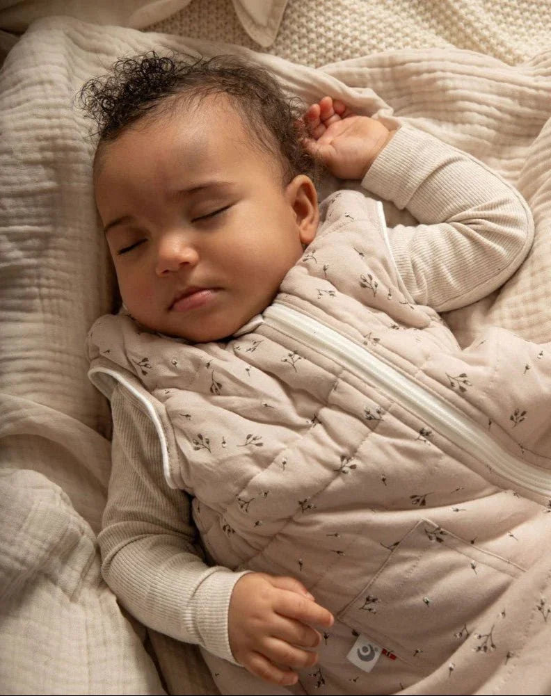 Søvende baby i myk, mønstret sengetøy og ullklær, perfekt for bebis 0-8 år