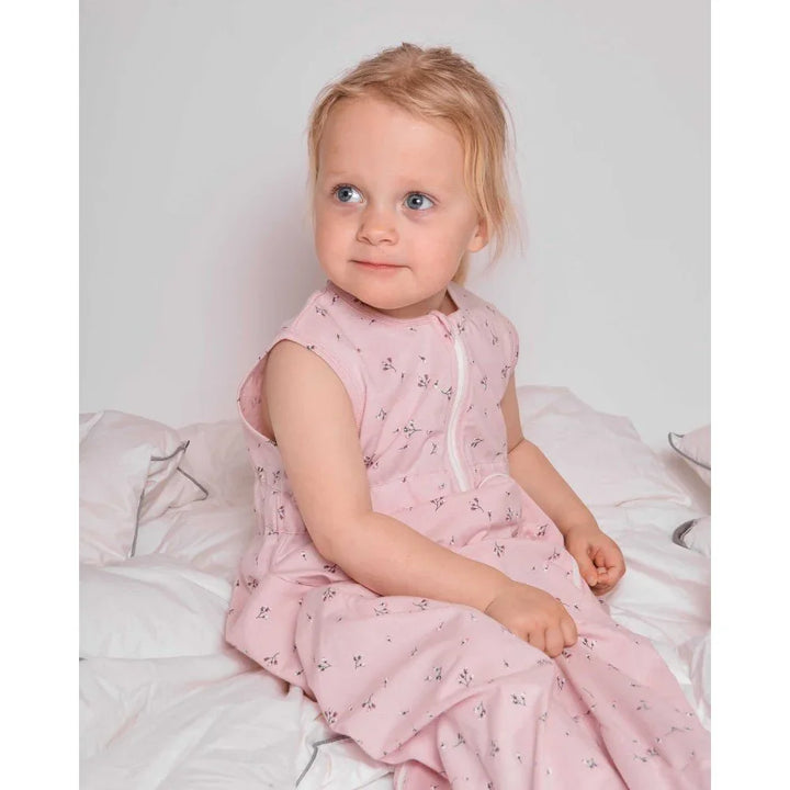 Liten jente i rosa blomsterpyjamas, myk barneklær for små barn