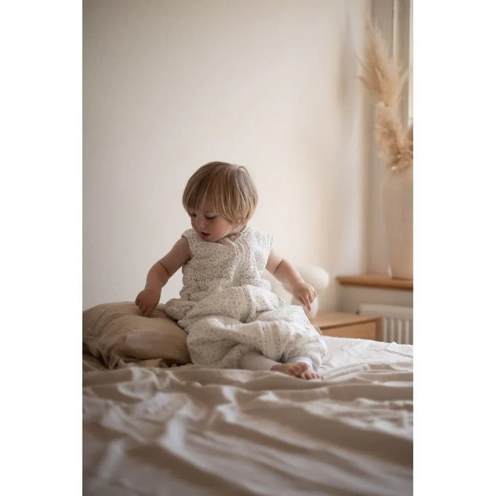 Liten baby i myk, blomsterprintet sengetøy, perfekt for bekvem søvn og daglig bruk.
