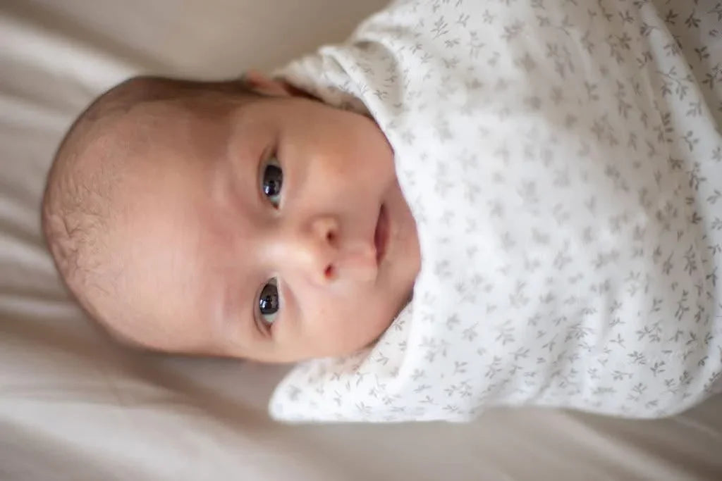 Nyfødt baby i myk, mønstret swaddle, perfekt for bekvemhet og trygghet