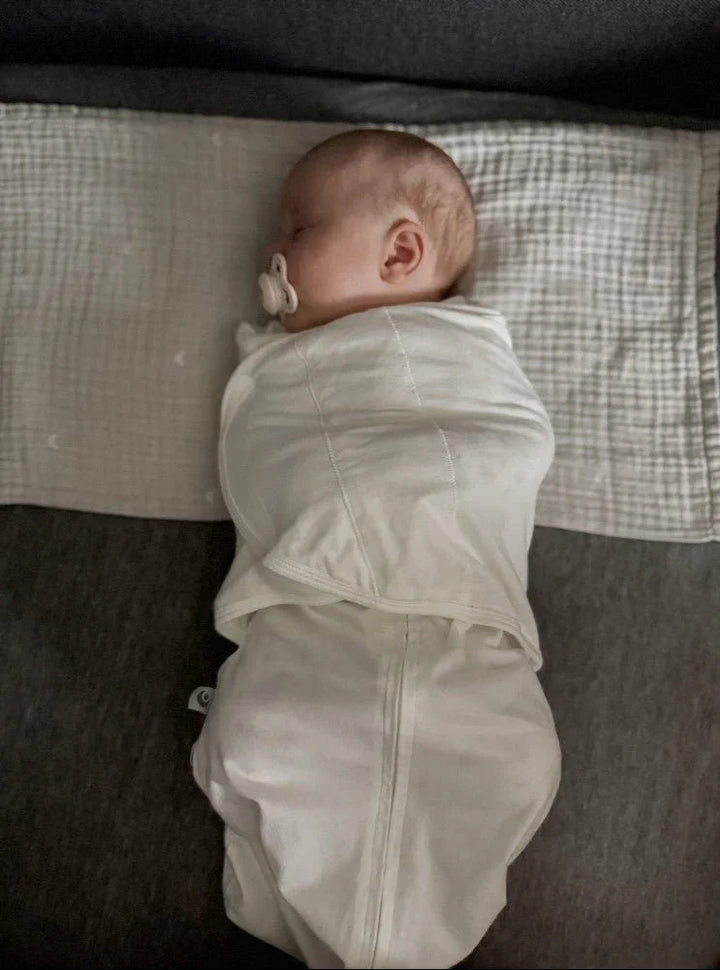 Søvndyktig baby i hvit svøpe med sugelapp, myk barneklær for nyfødte