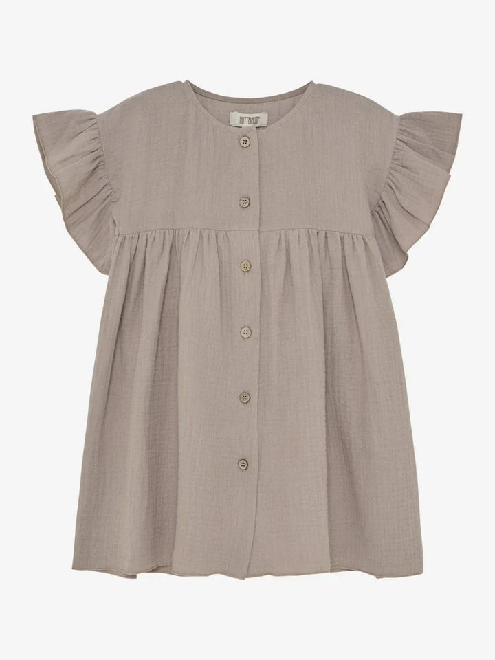 Myk beige barnebluse med rynkede ermer og knapper foran, perfekt for spedbarn og småbarn.