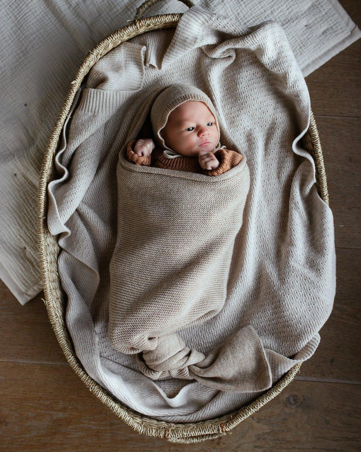 Nyfødt baby i myk ullklær og hette, viklet i strikket dekselet i korg, perfekt for 0-8 år