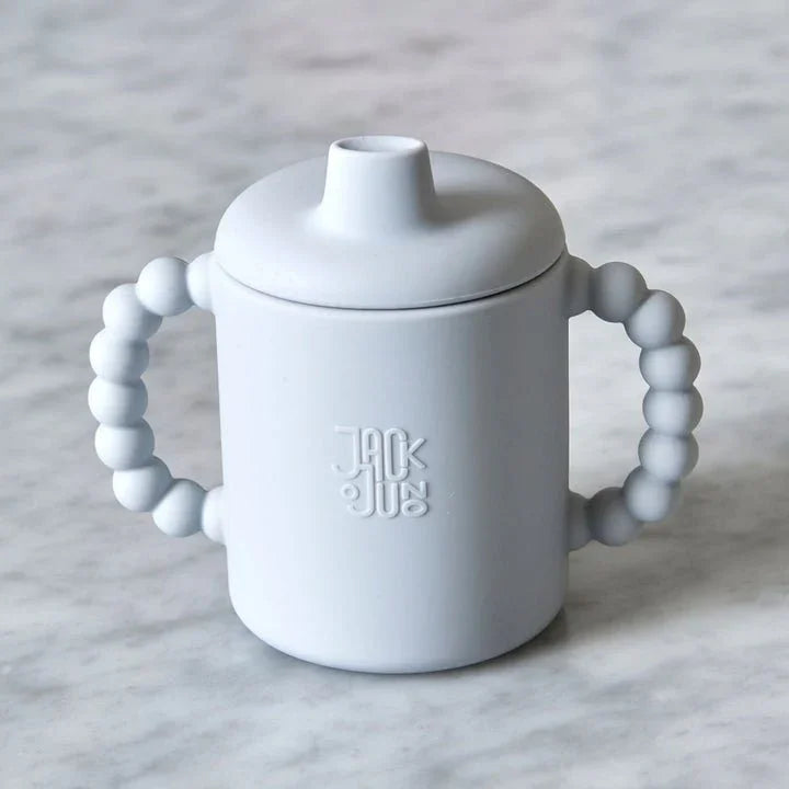 Hvit sippy cup med perlehandtak og Jack &amp; Jus-logo, ideell for spedbarn og småbarn