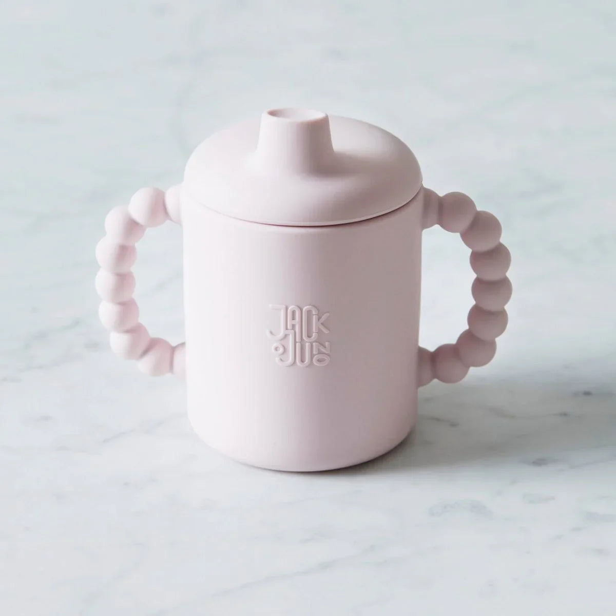 Lysrosa sippy cup med bevegelige håndtak og Jack & JUICE logo, perfekt for små barn.