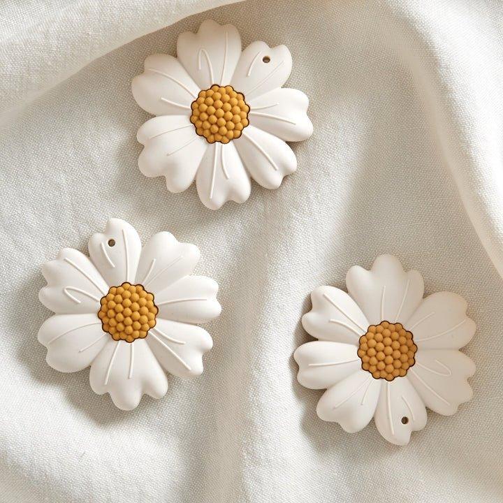 Tre hvite kamilleblomster med gule midter, myke barneklær tilbehør