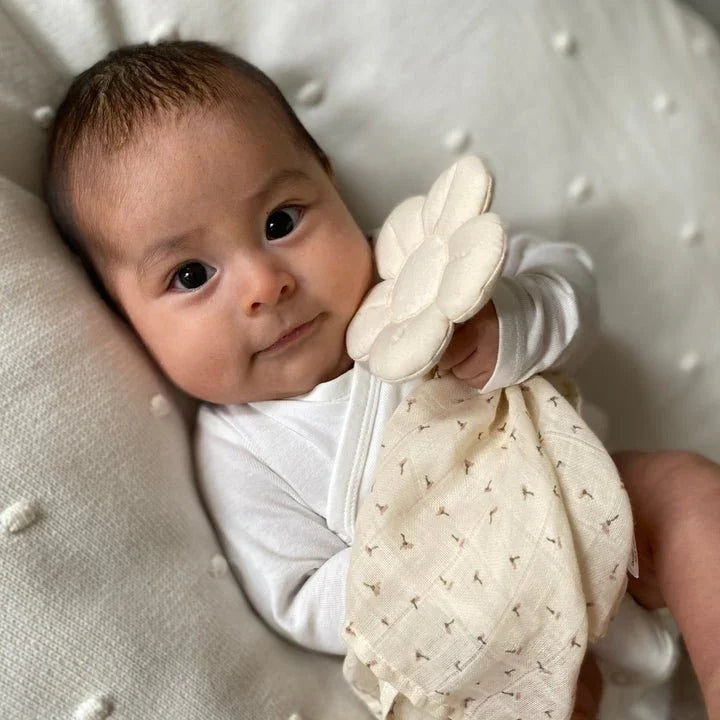 Søt baby i hvit body med blomsterklemme og mønstret lue, myke barneklær for spedbarn