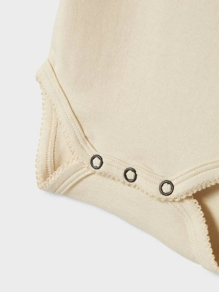 Myk babybody i naturlig farge med knapper for enkel skifte, perfekt for spedbarn 0-8 år