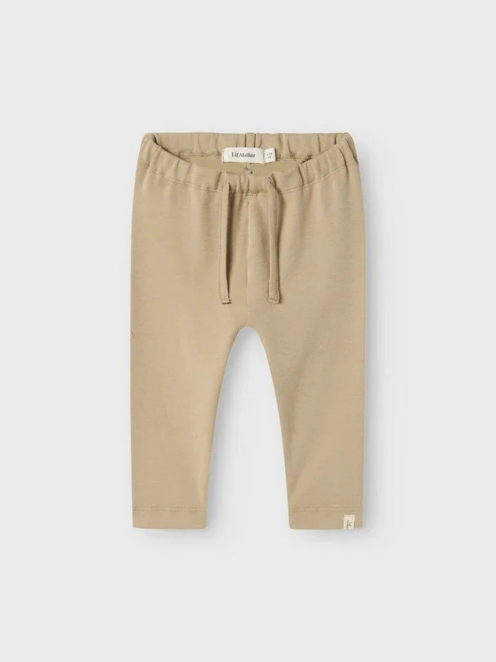 Beige babybukser med elastisk liv og trekord, myke og bekveme for spedbarn og småbarn.