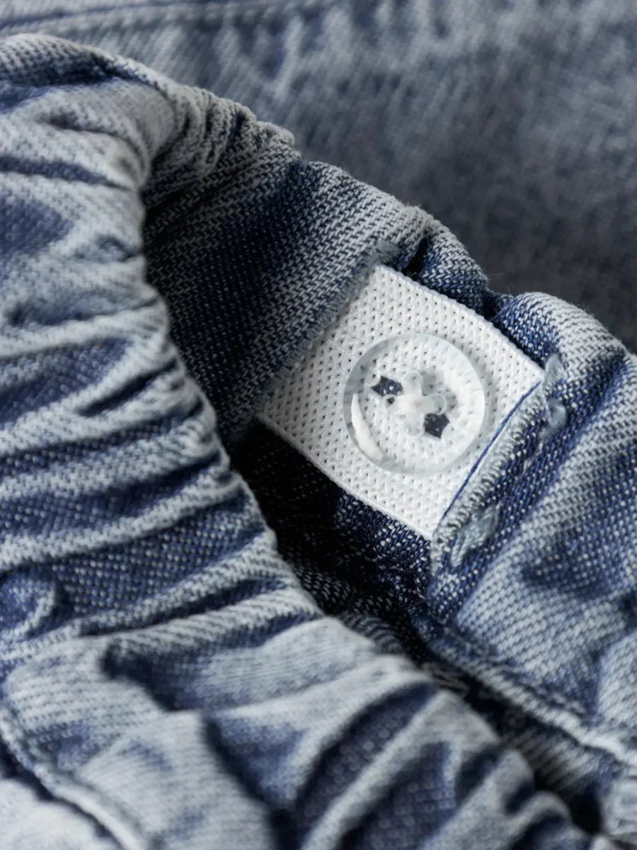 Blå denim bukse for barn med hvit knapp og elastisk liv, myk og bærekraftig barneklær