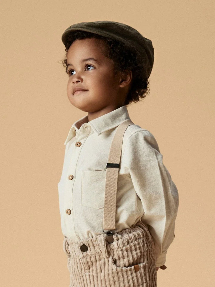 Liten gutt i myk barneklær med skjorte, bukser og lue, bærekraftig utstyr for små barn