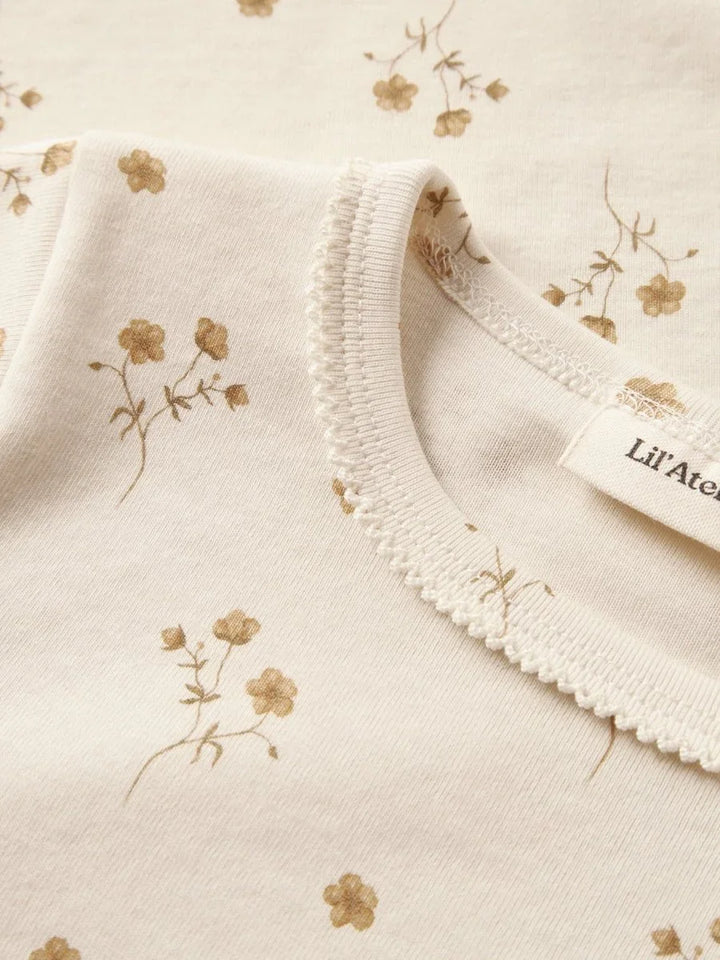 Myk babybody med blomstermønster i naturfarger, perfekt for spedbarn og småbarn.