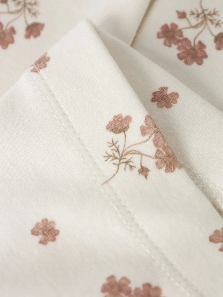 Myk barneklær med blomstermønster i rosa og beige, perfekt for spedbarn og småbarn