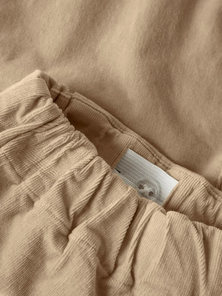 Myk beige barnebukse i ullblanding med elastisk liv og knapp, perfekt for bebis og småbarn