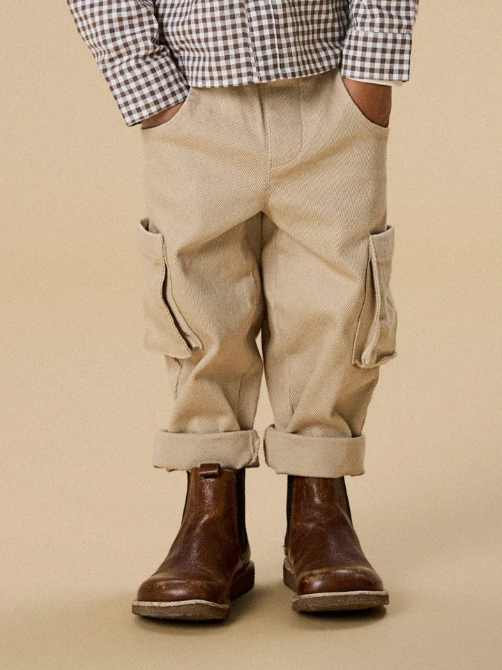 Barn i beige corduroy bukser med lommer, rullet nederkant og brun sko, perfekt for 0-8 år