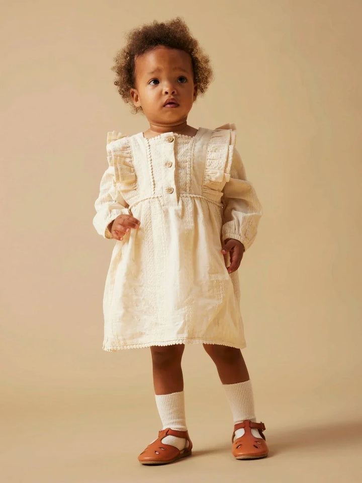 Liten jente i hvit, myk barneklær med rynker og knapper, perfekt for baby og småbarn 0-8 år