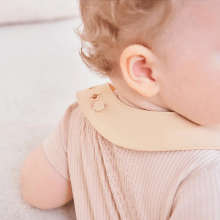 Baby i myk, ribbet barneklær med beige silikonekjele. Perfekt for spedbarn 0-8 år.