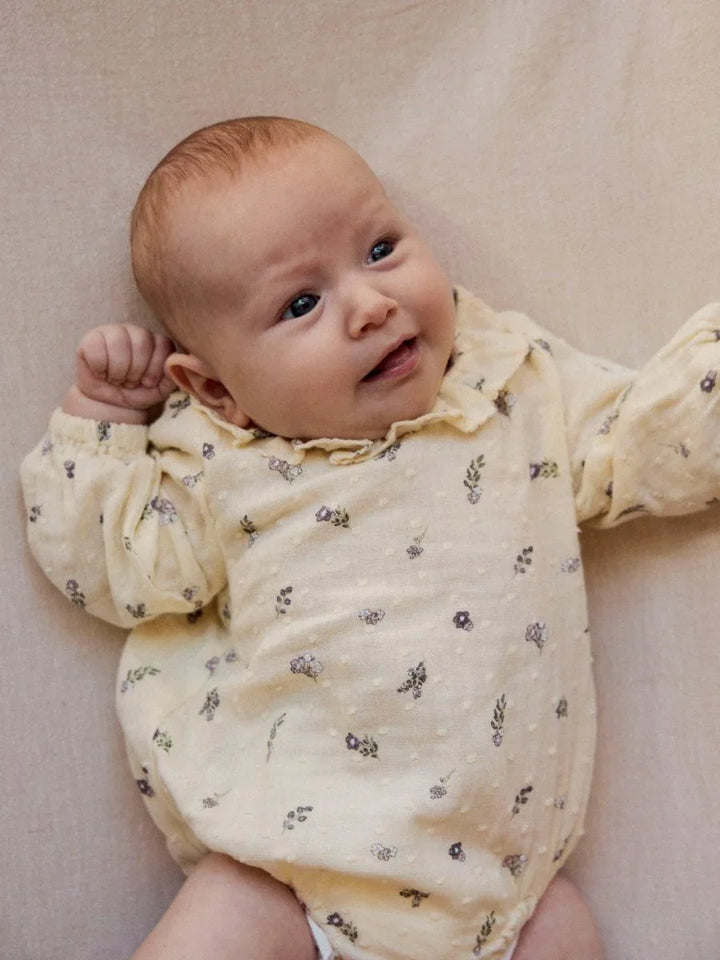 Liten baby i myk, blomsterprintet body, perfekt barneklær for spedbarn 0-8 år