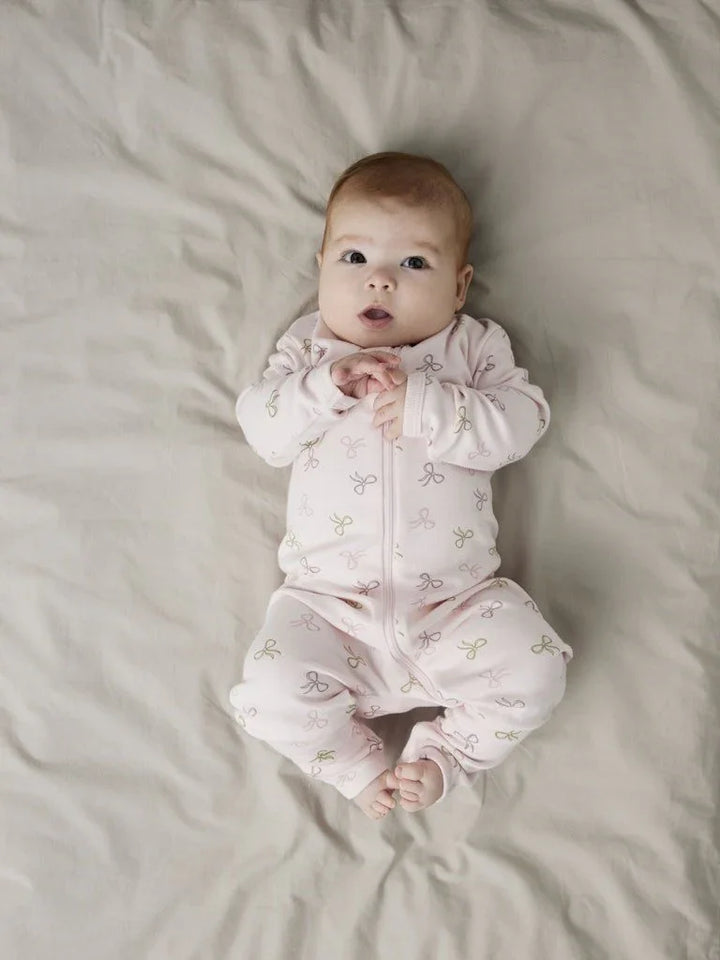 Søt baby i rosa pyjamas med bueprint, myk barneklær for spedbarn