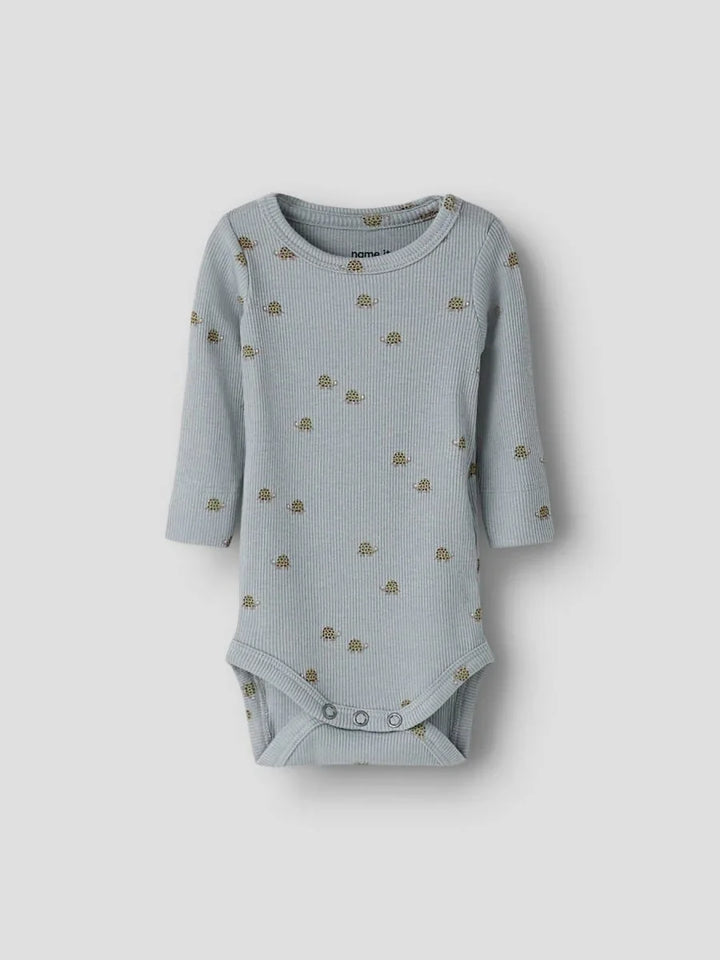 Myk blå babybody med skilpaddemønster og knapper nederst, perfekt for spedbarn 0-8 år.