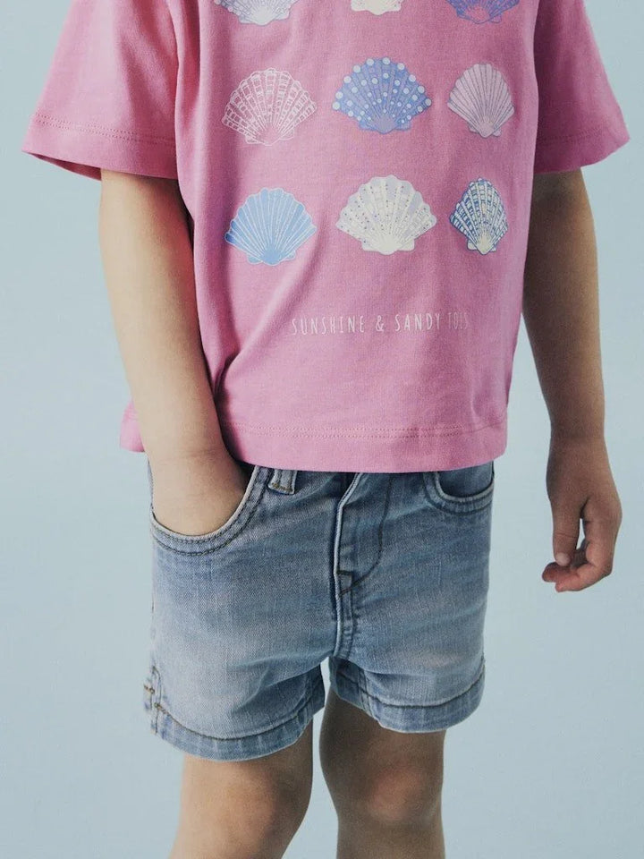 Rosa barne-T-skjorte med skjellmønster og jeansshorts, perfekt som sommerklær for barn.