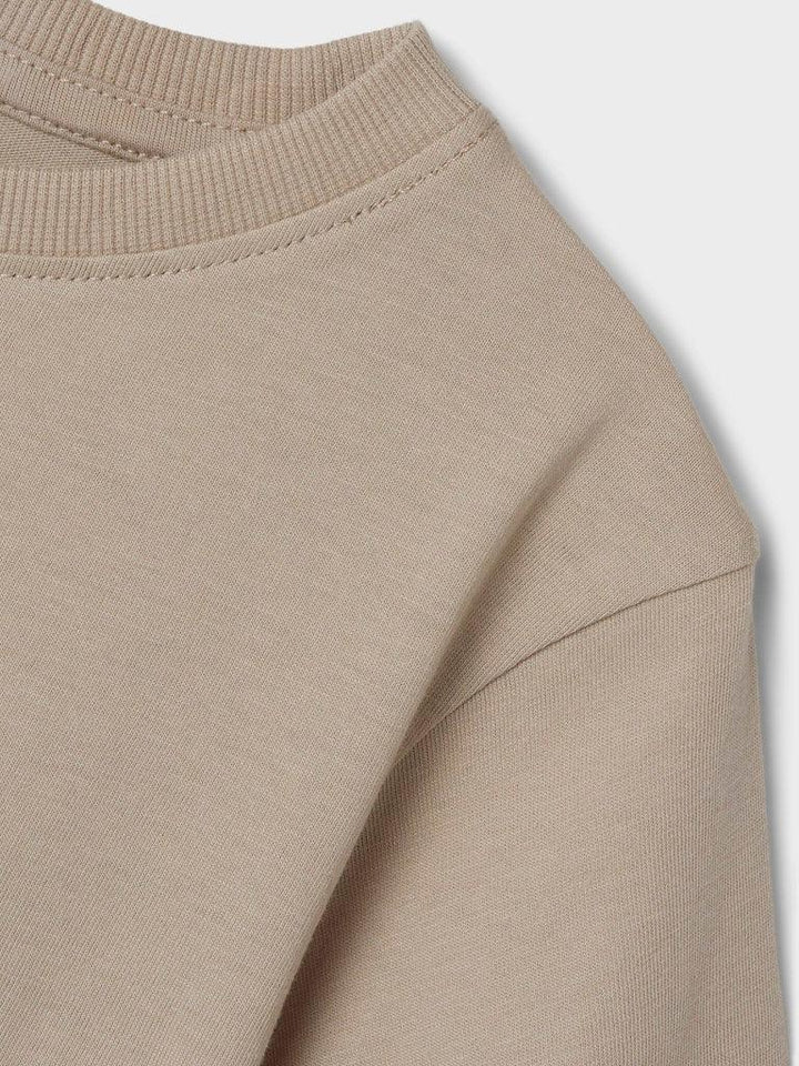 Myk beige barneklær med ribbet hals og kvalitetsstrik