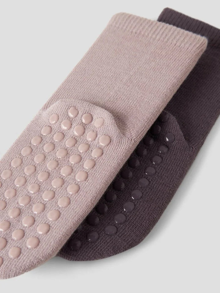 Myke barneklær med anti-skli-såler i rosa og mørk farge, perfekt for små barn.