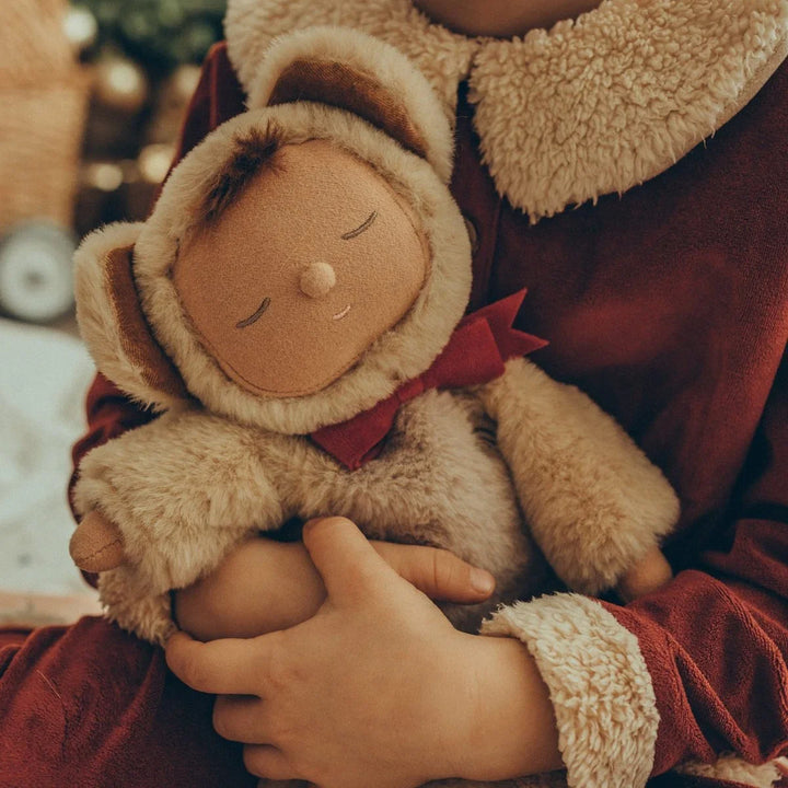 Myk ullbamse med rød strikk, holdt i barnets armer – perfekt babyutstyr for 0-8 år