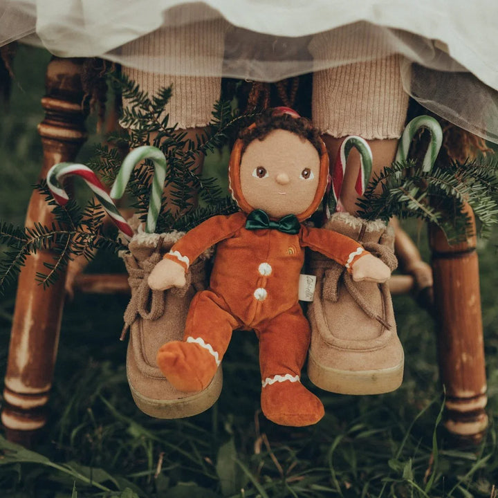 Gullig julepeis i orange med grønn slips, omgitt av julekarameller og gran, perfekt julegave for barn.