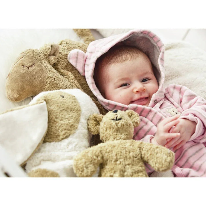 Smilende baby i rosa strikket hettegenser med myke bamser og ulldekket