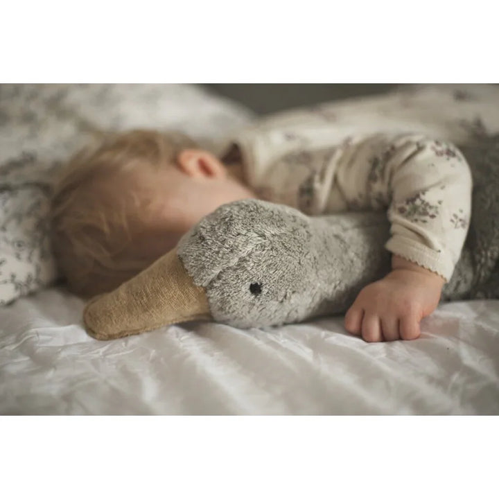 Søvnende baby i blomsterpyjamas med grå plysand