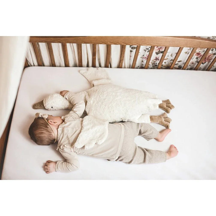 Baby i myk ullklær sover i seng med plys svane, ideelt for spedbarn 0-8 år