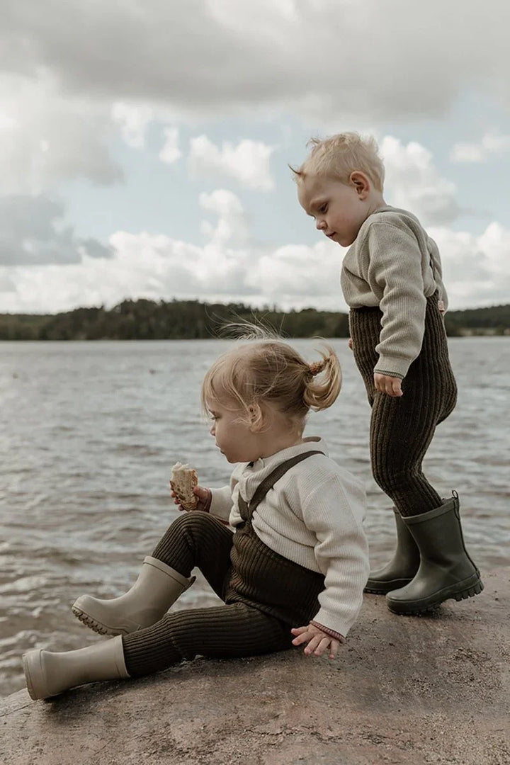 To små barn i myke barneklær og gummistøvler ved sjøen, 0-8 år