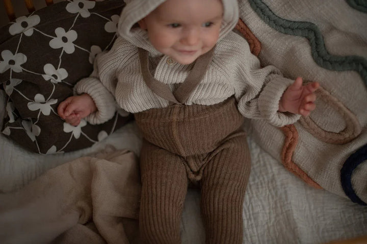 Liten baby i myk ullgenser og bukser, perfekt barneklær for små barn