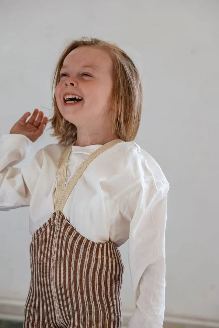 Lyst barn i strikkede bukser og hvit skjorte, myke barneklær for 0-8 år