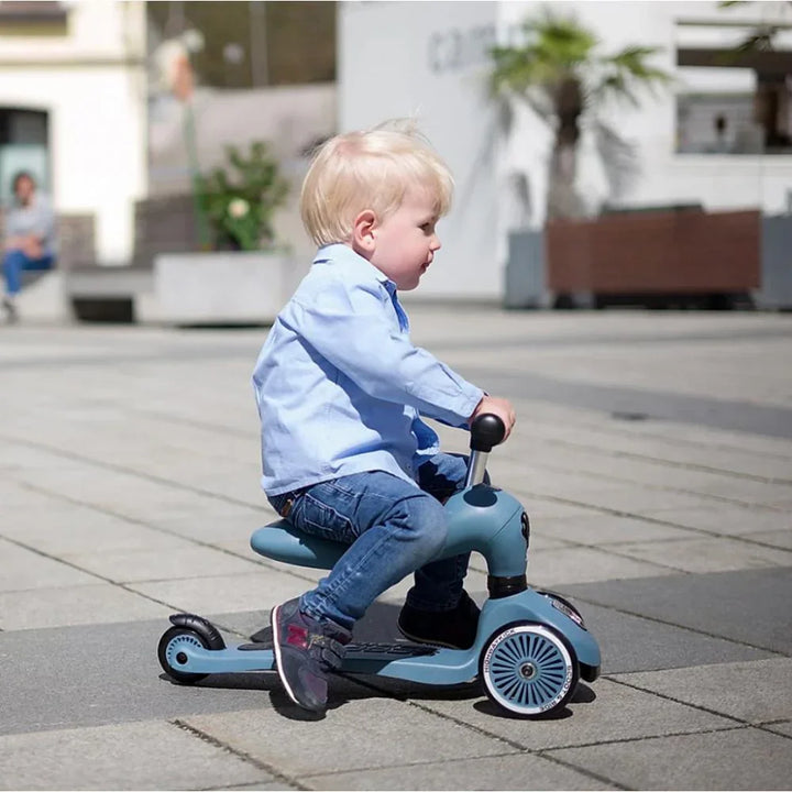 Liten gutt på blå sparkesykkel i bymiljø, barneklær og leketøy for 0-8 år